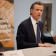 Gavin Newsom speaks into a microphone at a podium